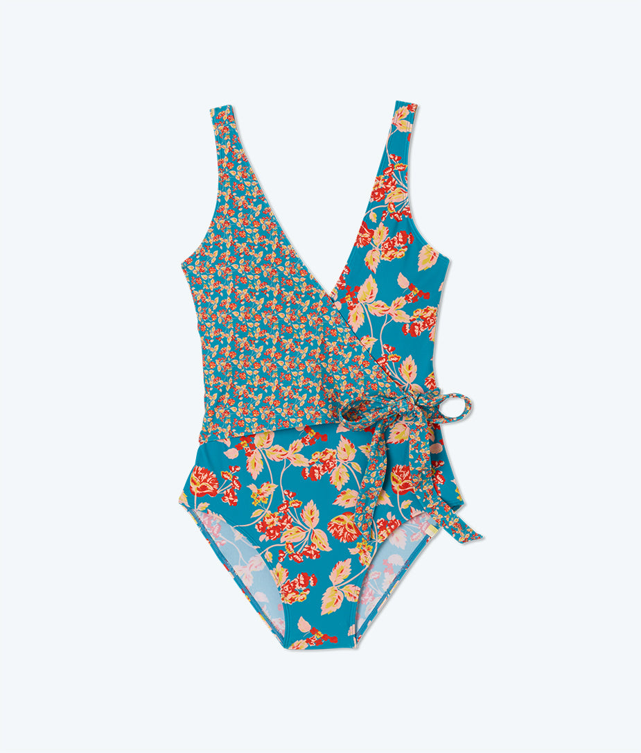 Model in One Piece Swimsuit, The Perfect Wrap One-Piece - Terrace Floral (Yellow,  Pink & Red Floral Pattern on Light Blue)